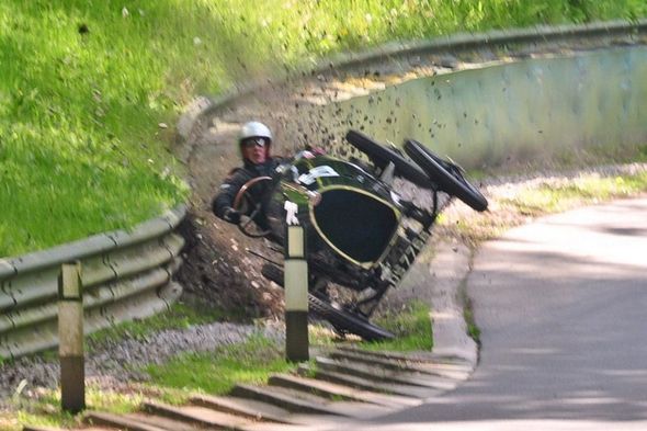 Photo d'une voiture de course ancienne qui rate un virage et qui va s'encastrer dans un poteau au niveau du capot. L'image est un peu floue et donne une impression de grande vitesse. Le pilote a l'air un peu inquiet...