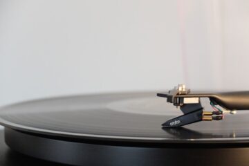 Side view of a vinyl record being read.