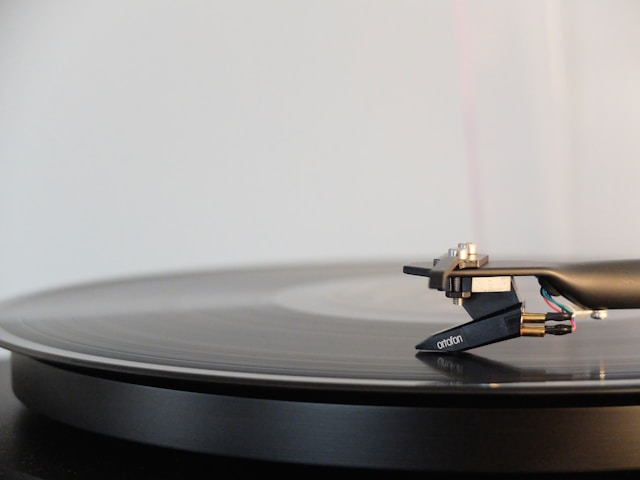 Side view of a vinyl record being read.